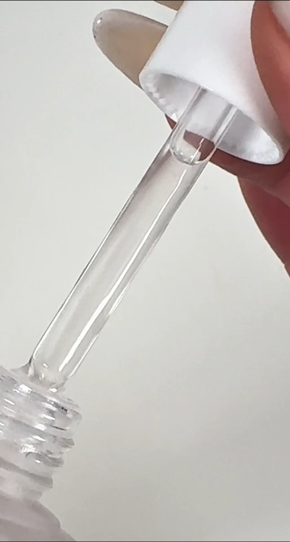 Close-up of the original Purple Ampoule Serum dropper and clear formula